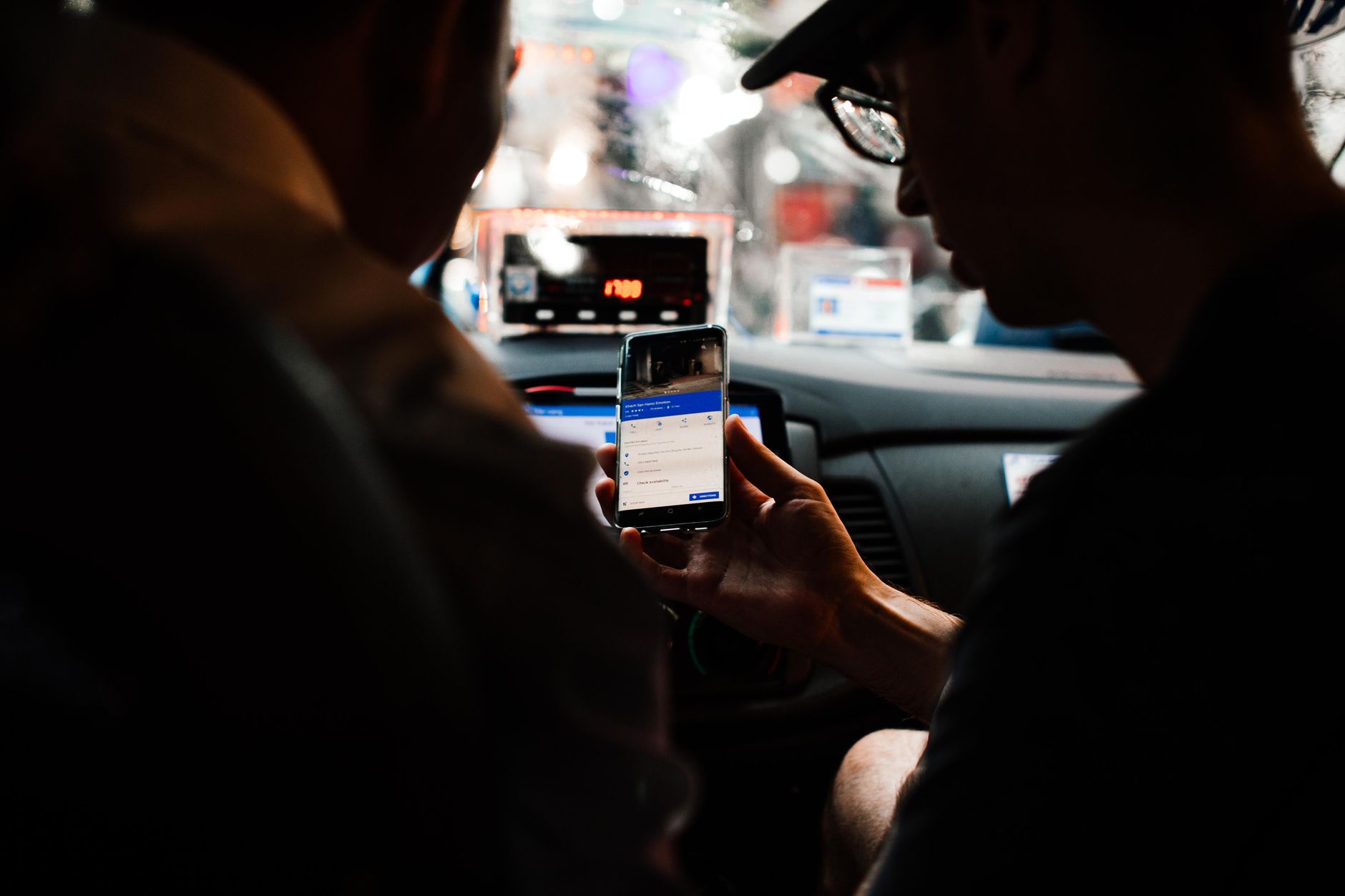 Motorista consultando o celular dentro do carro à noite
